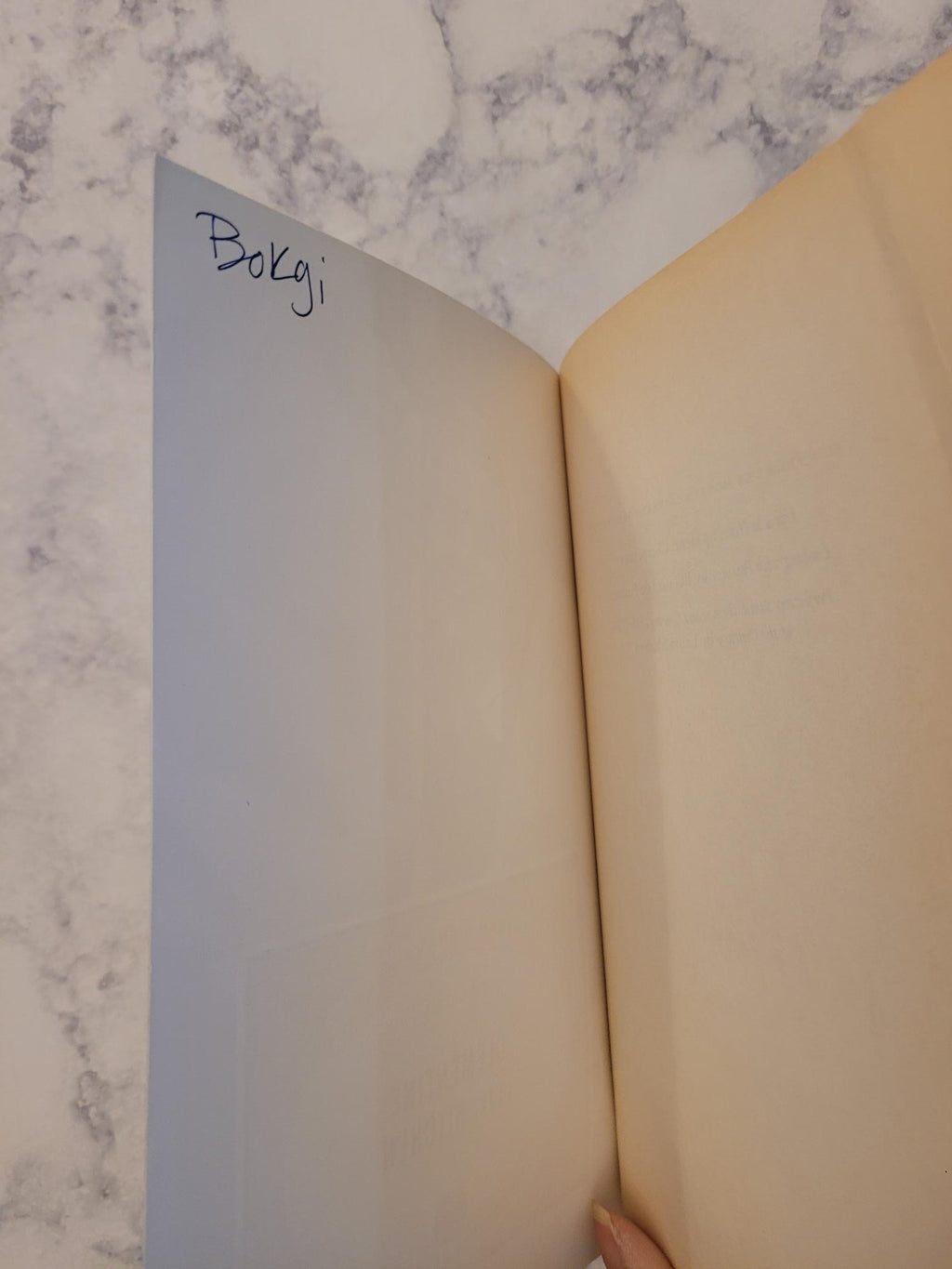 A large sheet of cream-colored cardstock or craft paper with a blue gradient printed section, shown open on a white marble surface. The word 'Bulgari' is written in black script on the blue section.