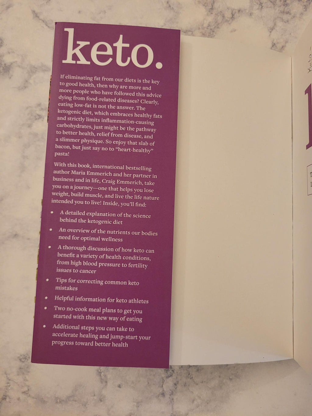A purple printed card or booklet insert with the word 'keto.' in large white text, placed on a white envelope over a light marble surface.