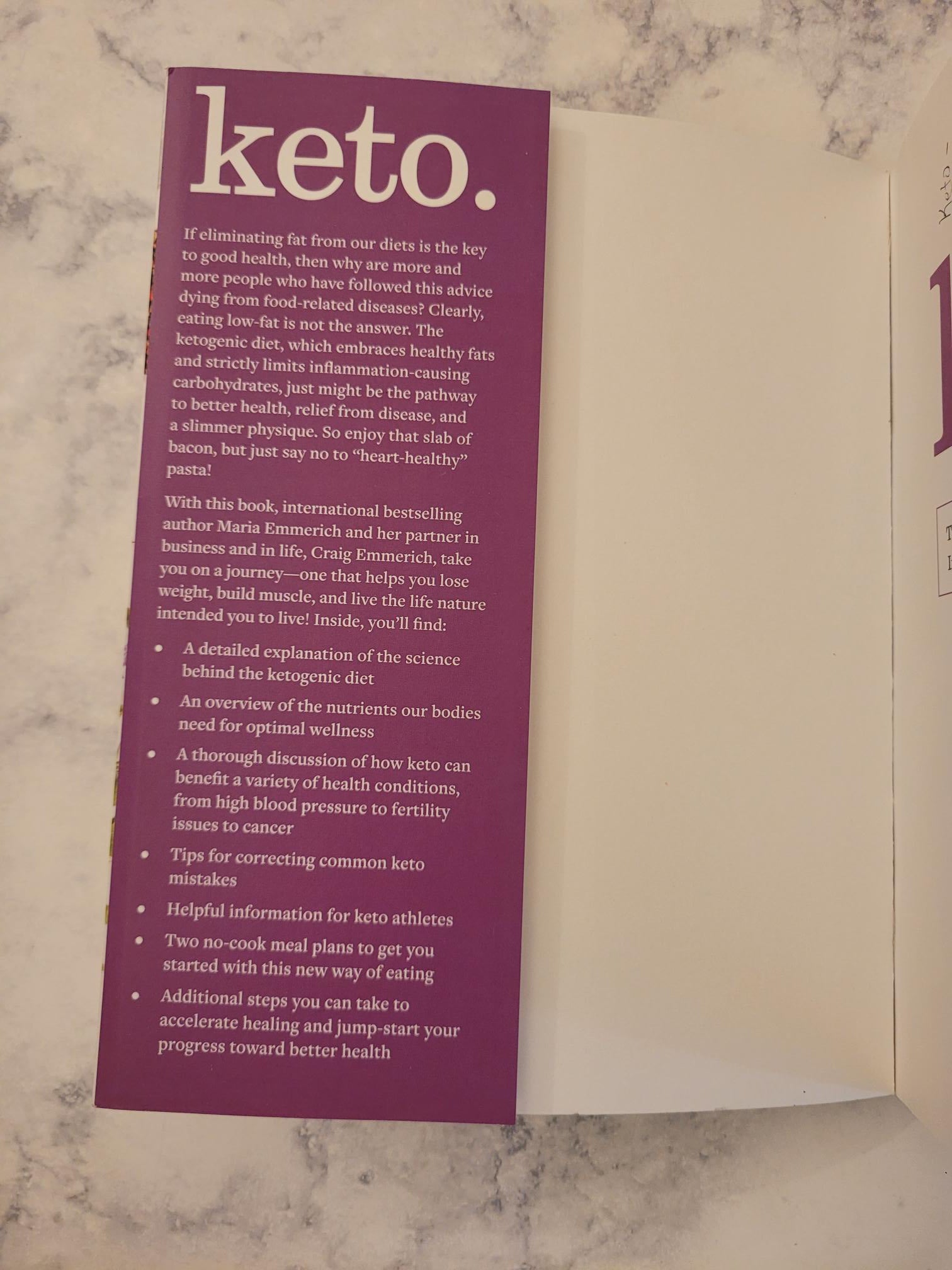 A purple printed card or booklet insert with the word 'keto.' in large white text, placed on a white envelope over a light marble surface.