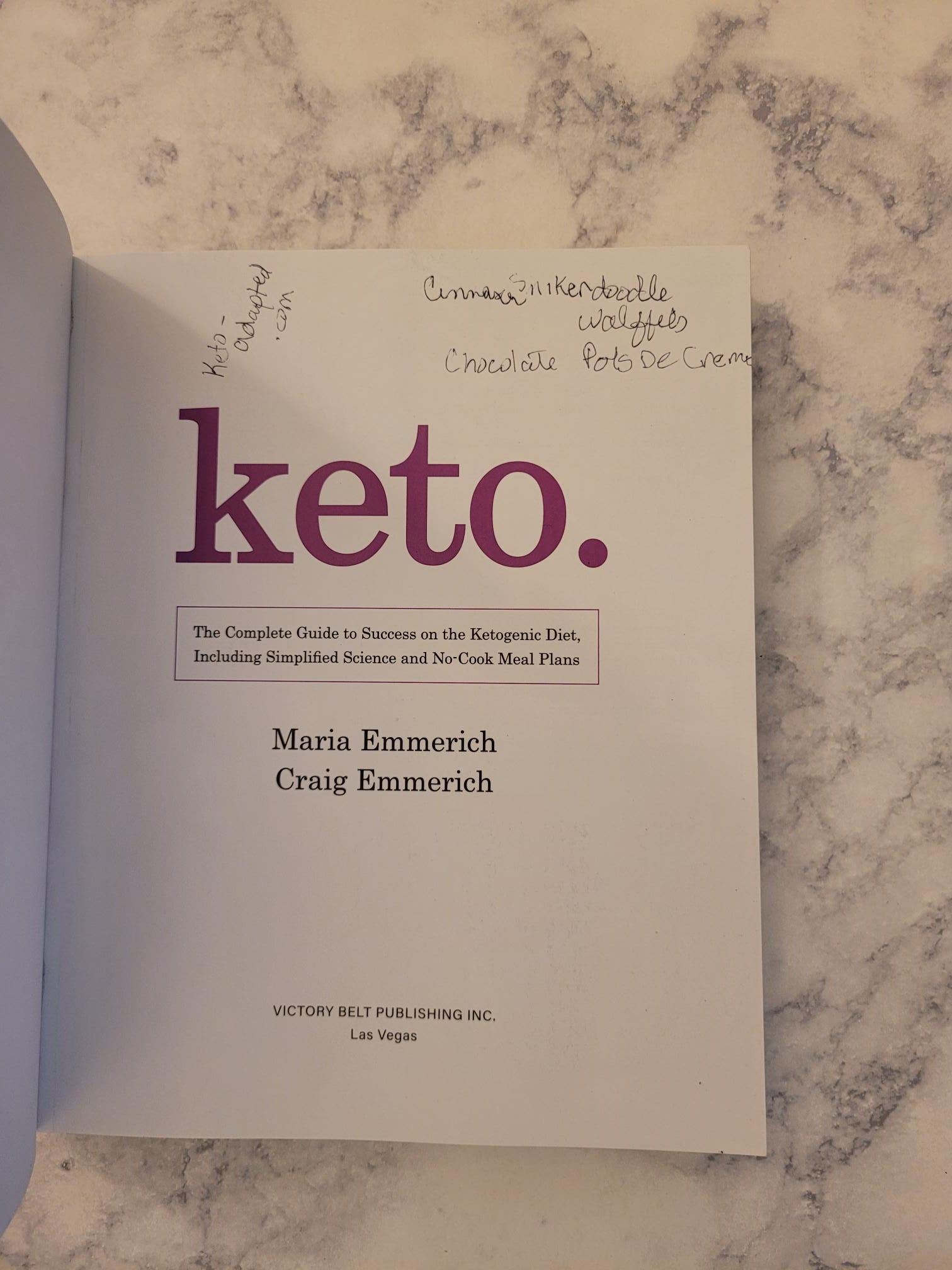A book titled 'keto.' by Maria Enmerich and Craig Enmerich, lying open on a gray and white marble surface.