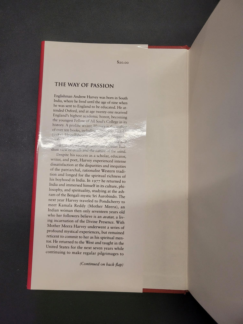 An open book or booklet showing printed text on a white page with a red border, photographed from above against a dark surface.