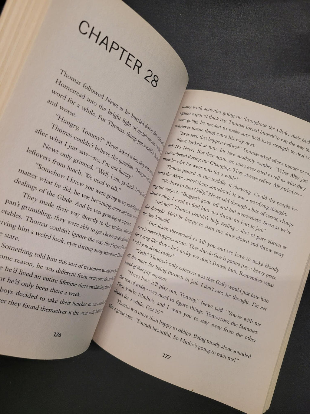An open book showing printed text on cream-colored pages, photographed from above against a dark gray background.