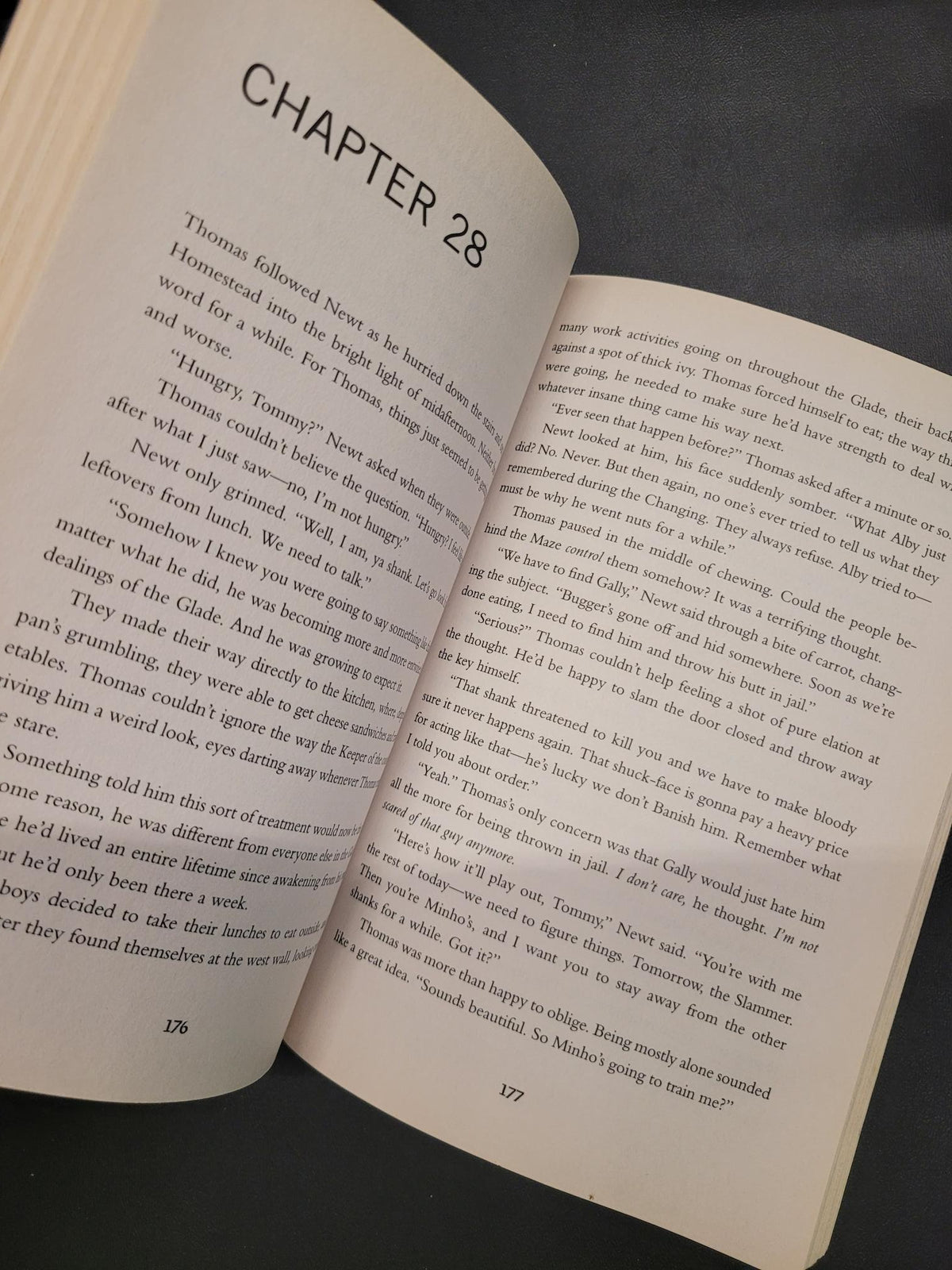 An open book showing printed text on cream-colored pages, photographed from above against a dark gray background.