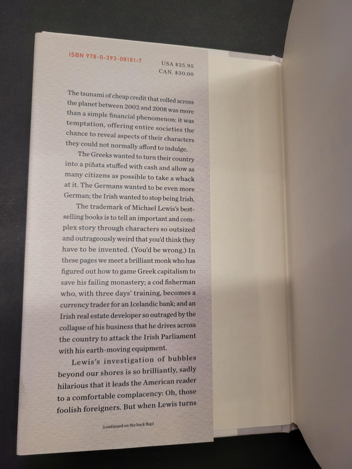 A book's interior page with printed text, photographed from above on a dark surface with the white book cover visible behind it.