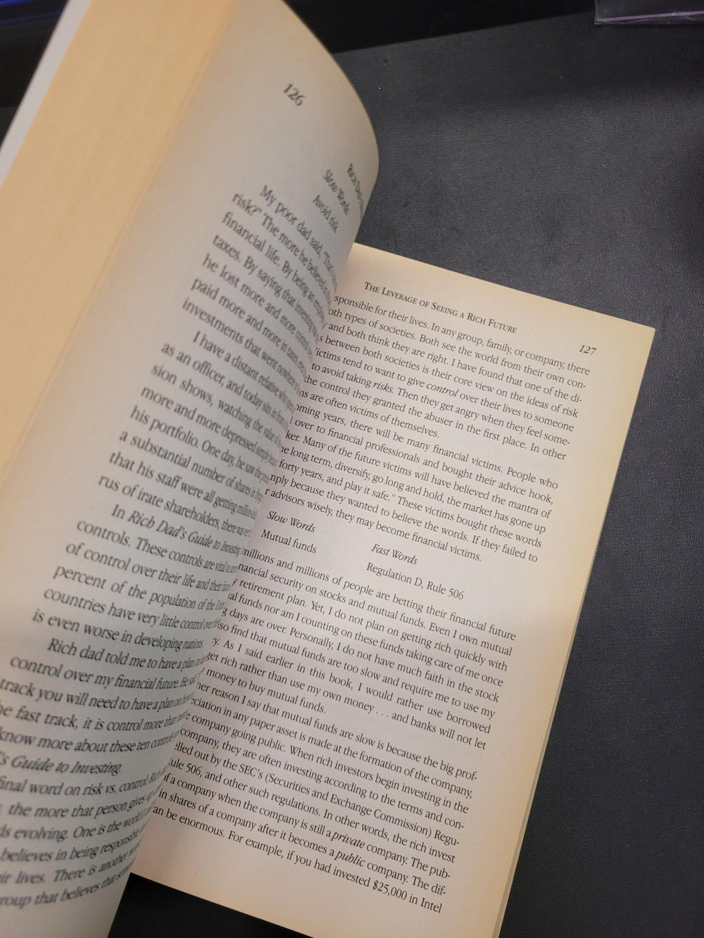 An open book with printed text on both pages, photographed against a dark gray background.