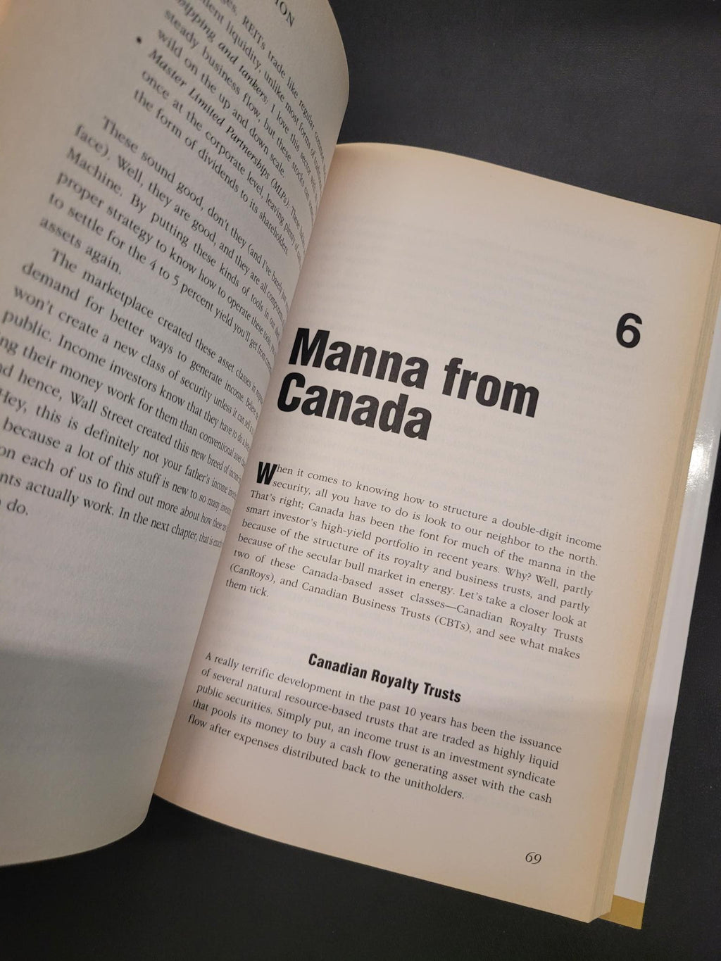 An open book showing printed pages with the heading 'Manna from Canada' and body text, photographed against a dark background.