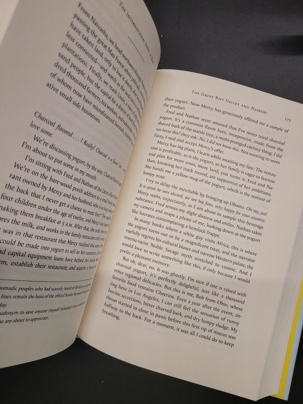An open book showing two printed pages with black text on cream paper, photographed at an angle with a dark surface around it.