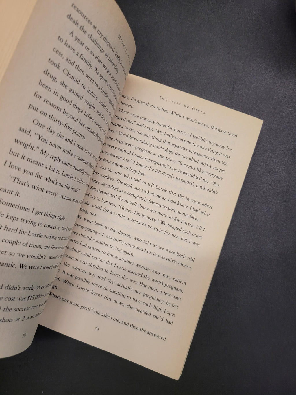 An open book with printed text spread across two pages, photographed against a dark textured background.