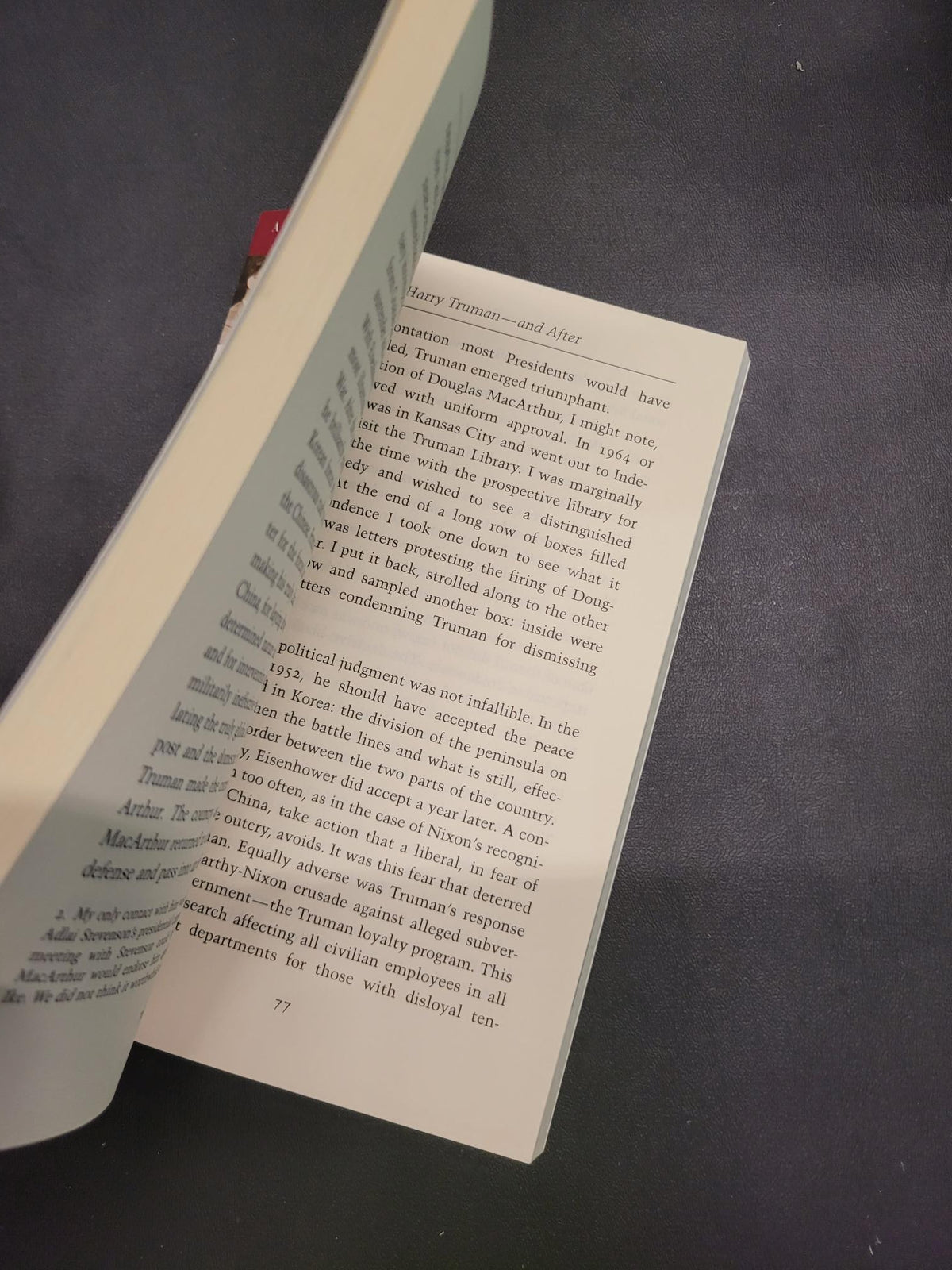 An open book with printed text pages, photographed from above on a dark textured surface.