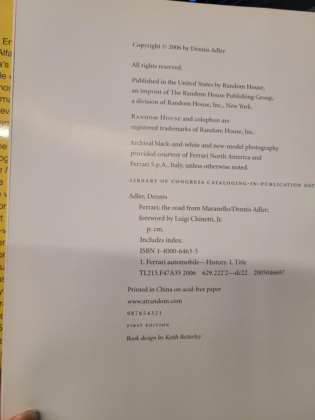 A close-up of a book's copyright page printed on white paper, photographed sideways with a finger visible at the top edge.