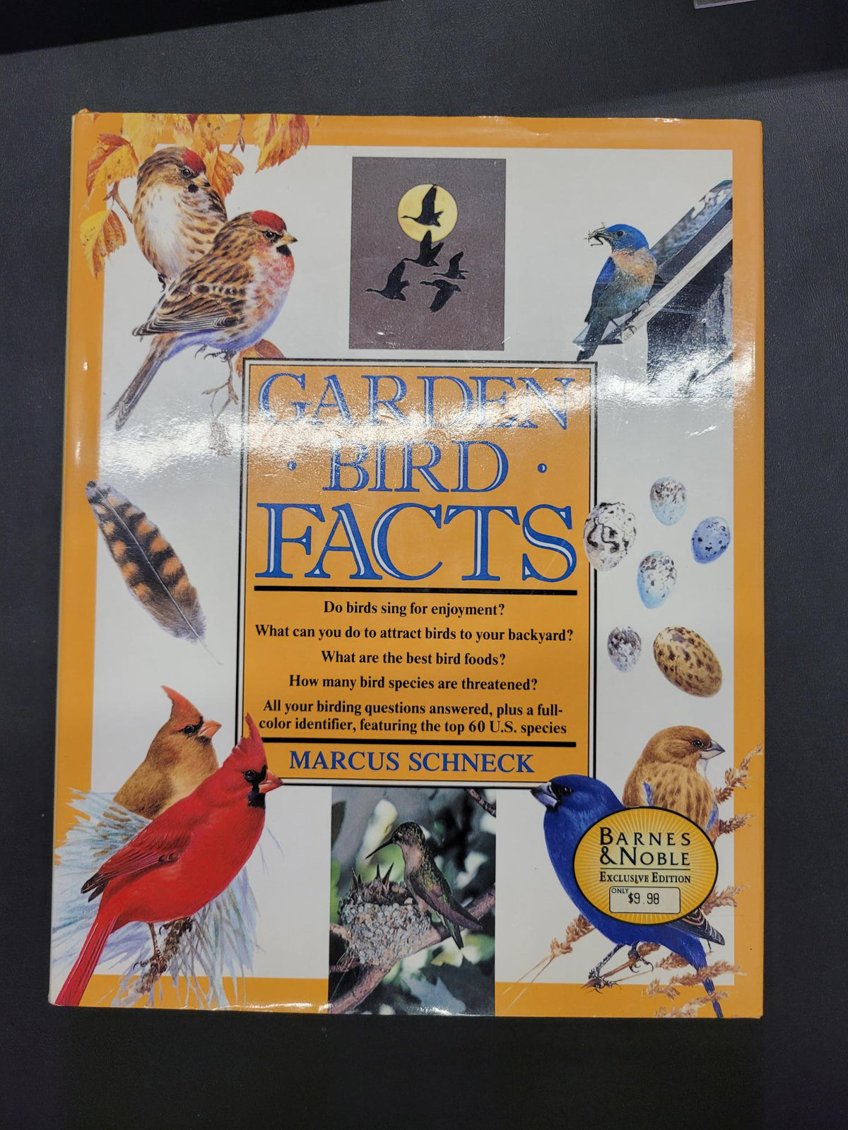 The front cover of the book 'Garden Bird Facts' by Marcus Schneck, featuring a bright yellow border and various colorful illustrations of different bird species. A Barnes & Noble Excellence Edition sticker is visible in the bottom right corner.