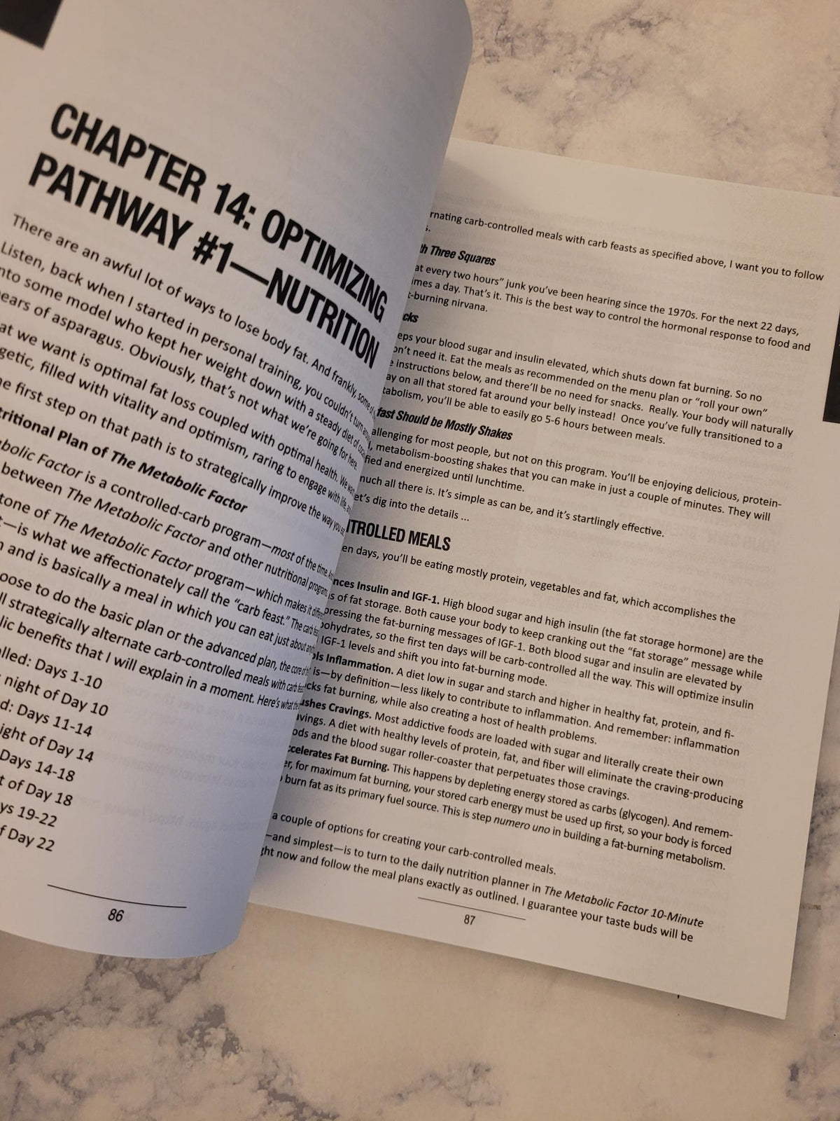 An open book or booklet showing printed text, with the left page titled 'CHAPTER 14: OPTIMIZING PATHWAY #1 — NUTRITION,' photographed on a light marble-like surface.
