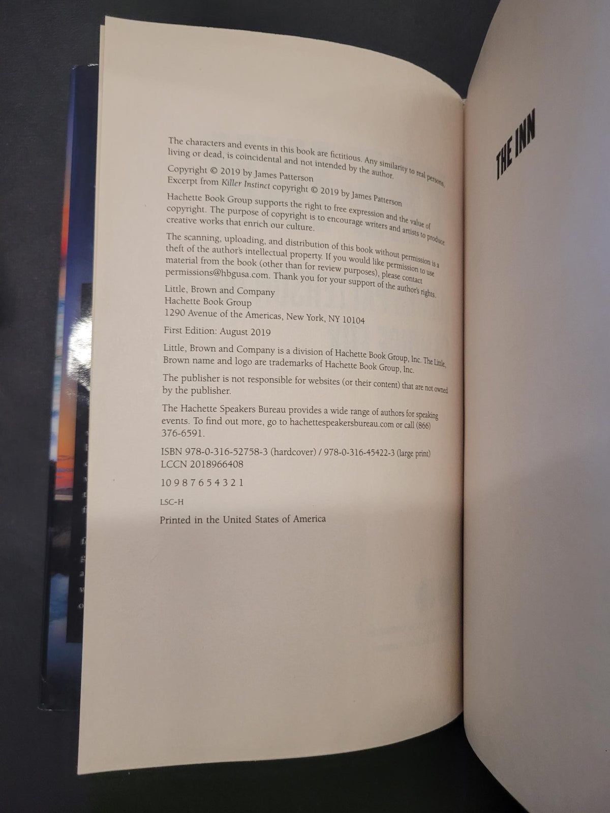 An open book showing the copyright page with printed text on cream-colored pages, photographed from above on a dark surface.
