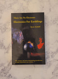 A paperback book titled 'There Are No Electrons: Electronics For Earthlings' by Kenn Andahl, lying flat on a white and gray marble-patterned surface.