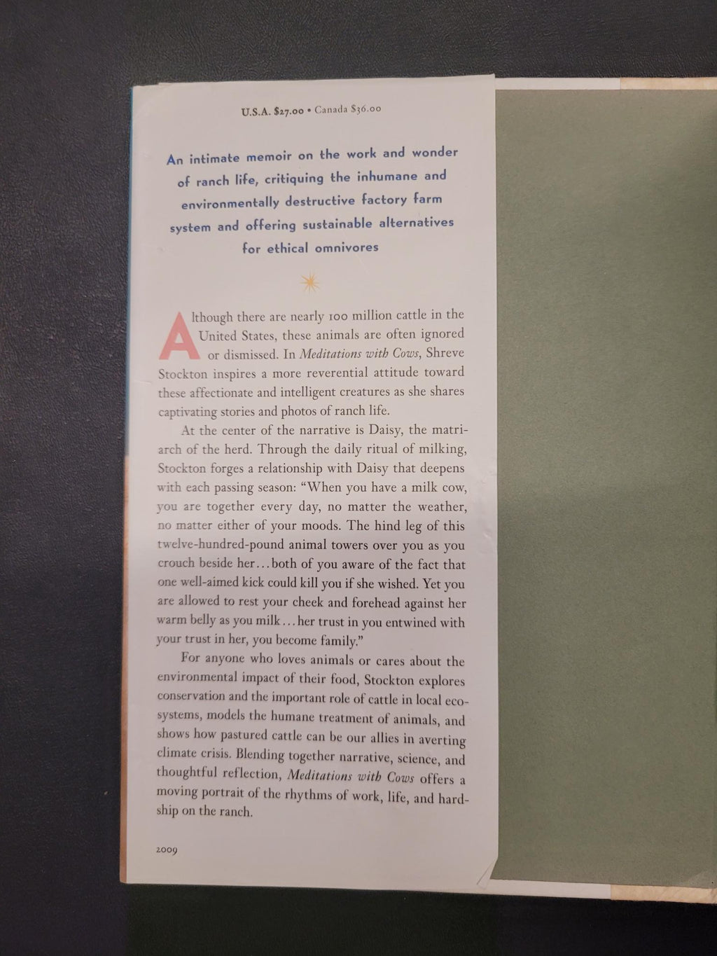 A printed page from a book or magazine laid flat on a dark surface, showing columns of black text on an off-white page with a large red letter 'A' at the top left.