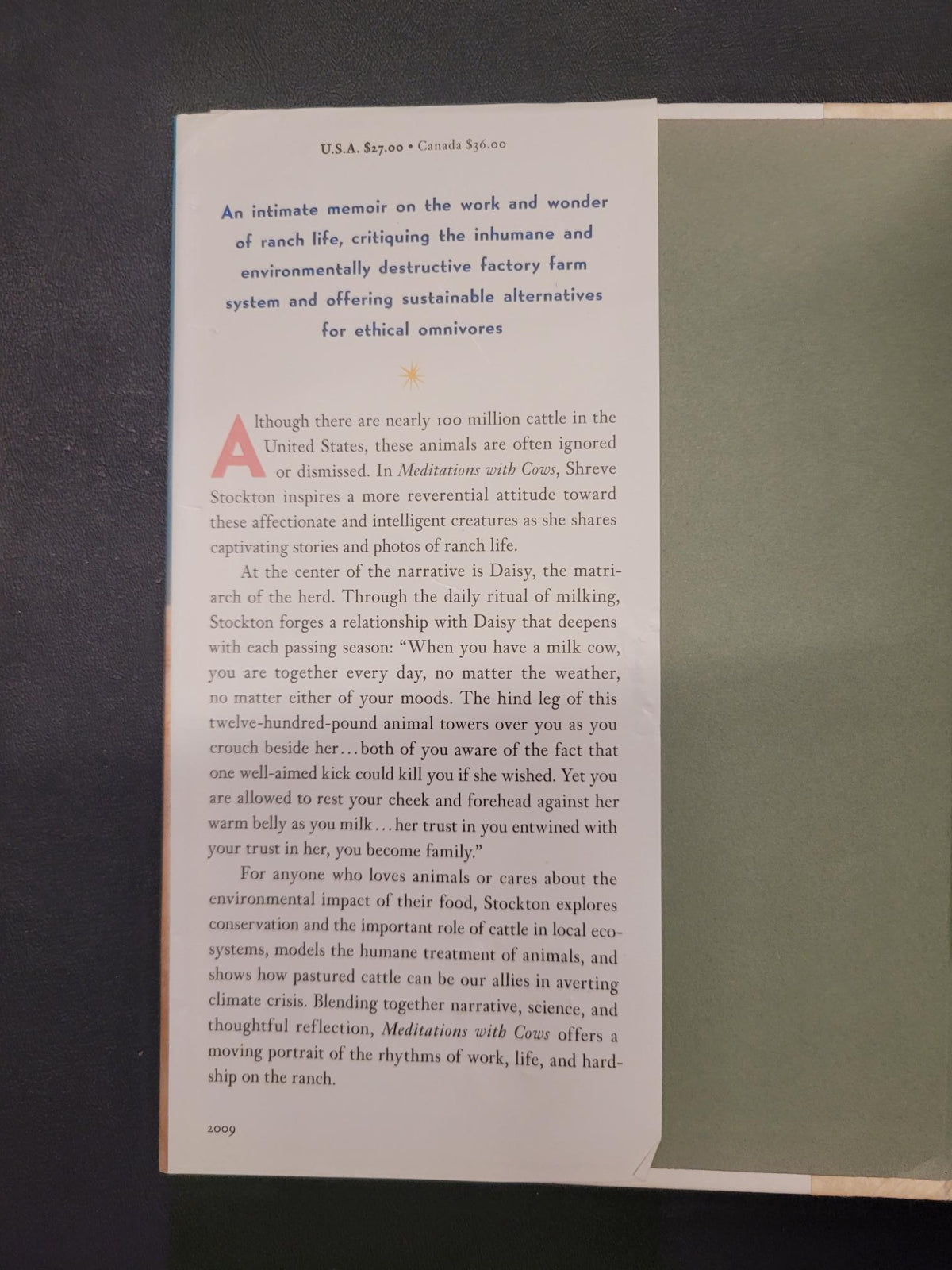 A printed page from a book or magazine laid flat on a dark surface, showing columns of black text on an off-white page with a large red letter 'A' at the top left.