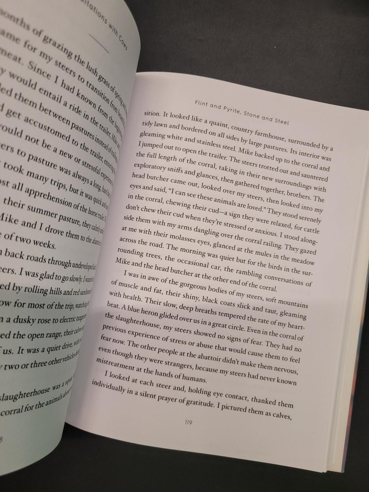 An open book showing printed text on two pages, photographed from above at a slight angle against a dark background.