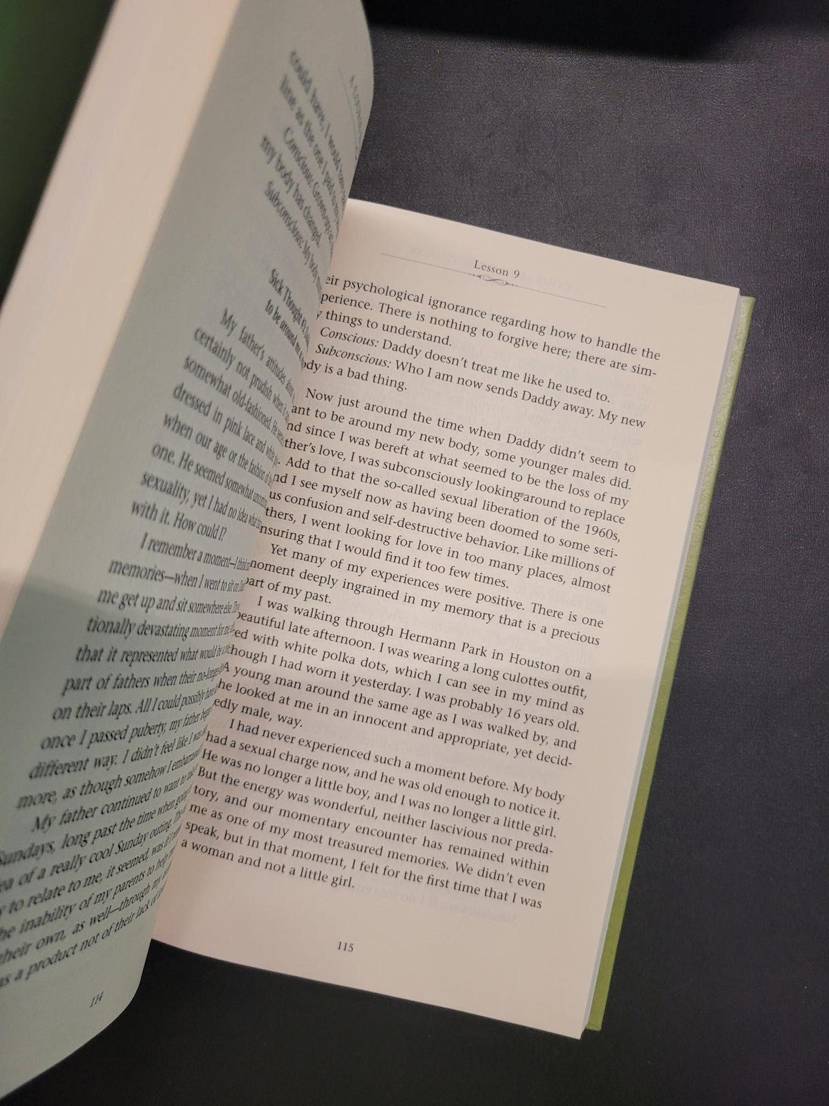 An open book with printed text pages, photographed at an angle against a dark gray background.