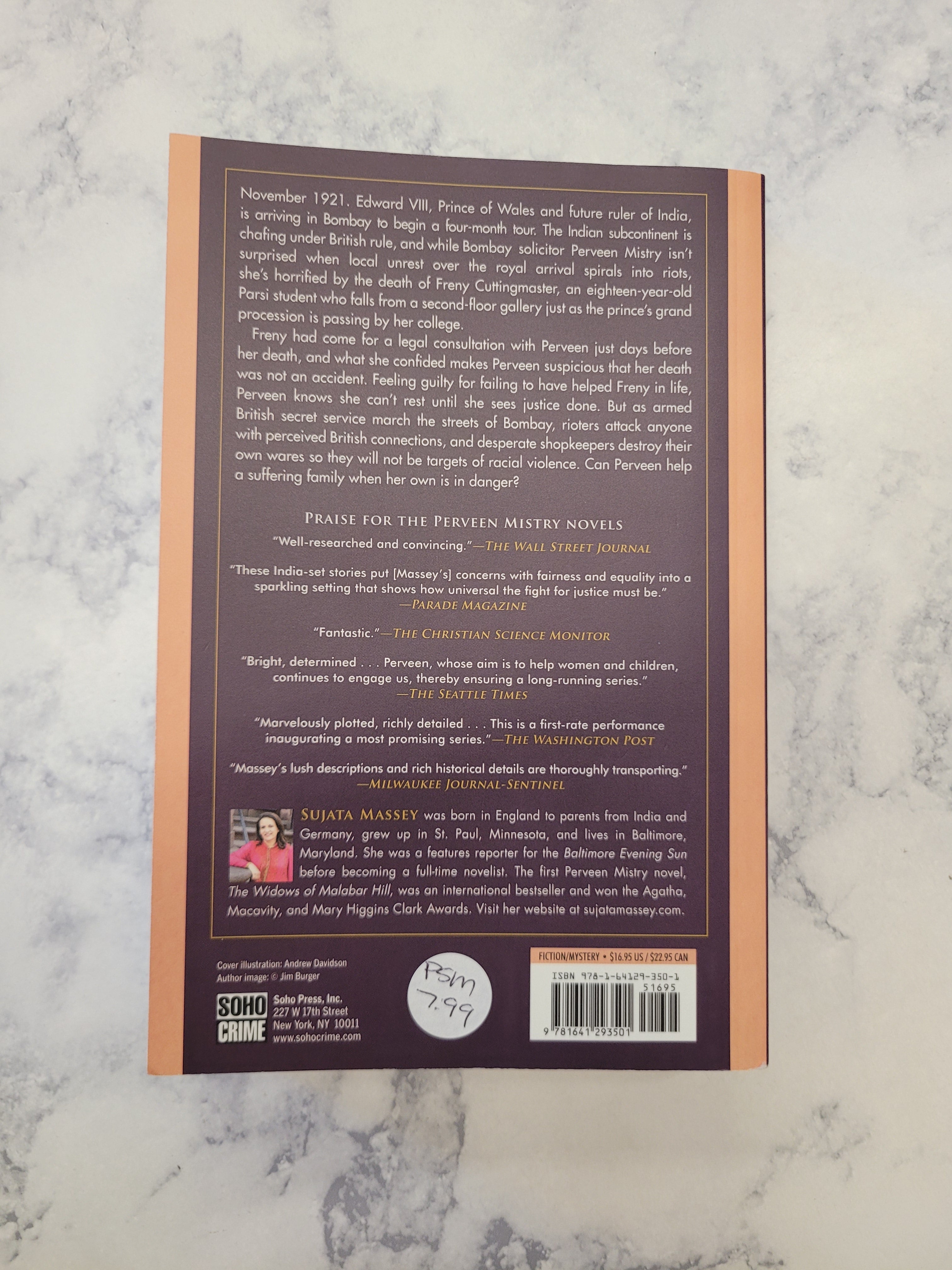 The back cover of a book features a dark purple background with white text, a peach border, and a barcode with a handwritten price sticker.