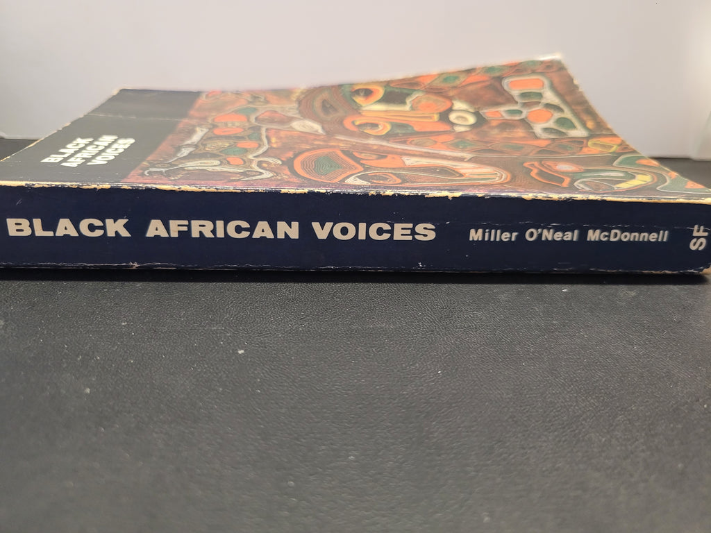 A vintage book titled 'Black African Voices' by Miller O'Neal McDonnell, featuring a black spine with white lettering and a colorful illustrated cover, resting on a dark gray surface.