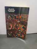 A vintage book titled 'Black African Voices' with a black cover and an abstract painted illustration in orange, red, green, and brown tones, standing on a gray surface against a white wall.