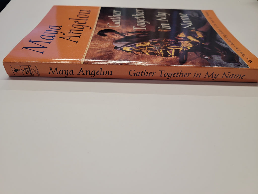 A paperback book titled 'Gather Together in My Name' by Maya Angelou, featuring an orange cover with a photograph of a person and the author's name printed on the spine.
