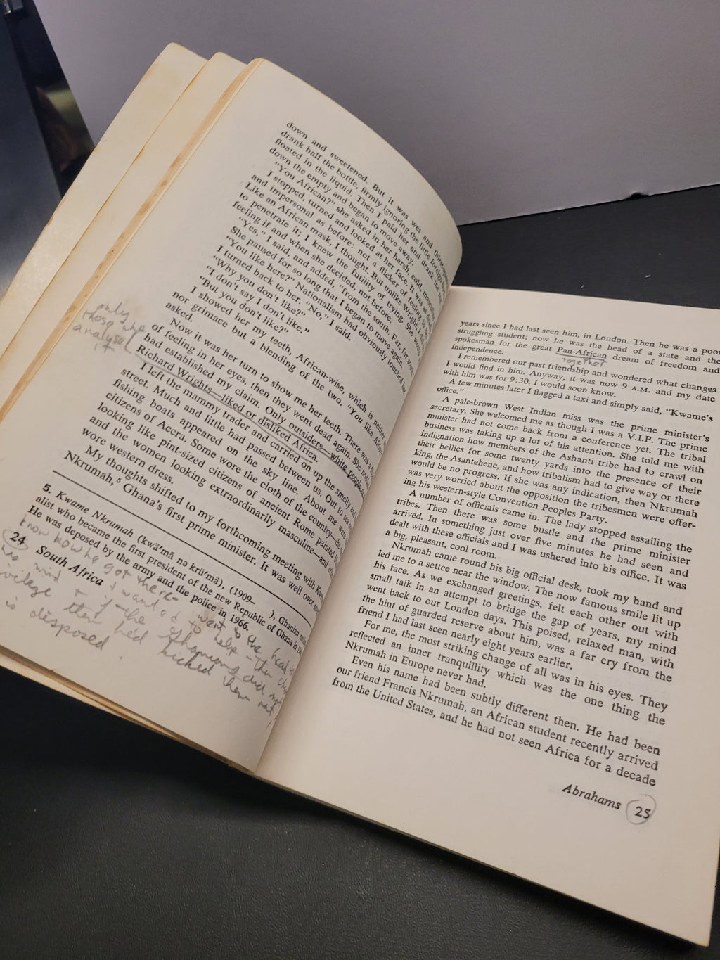 An open vintage book "Black African Voices" with handwritten notes on the left page, photographed from above on a dark surface.