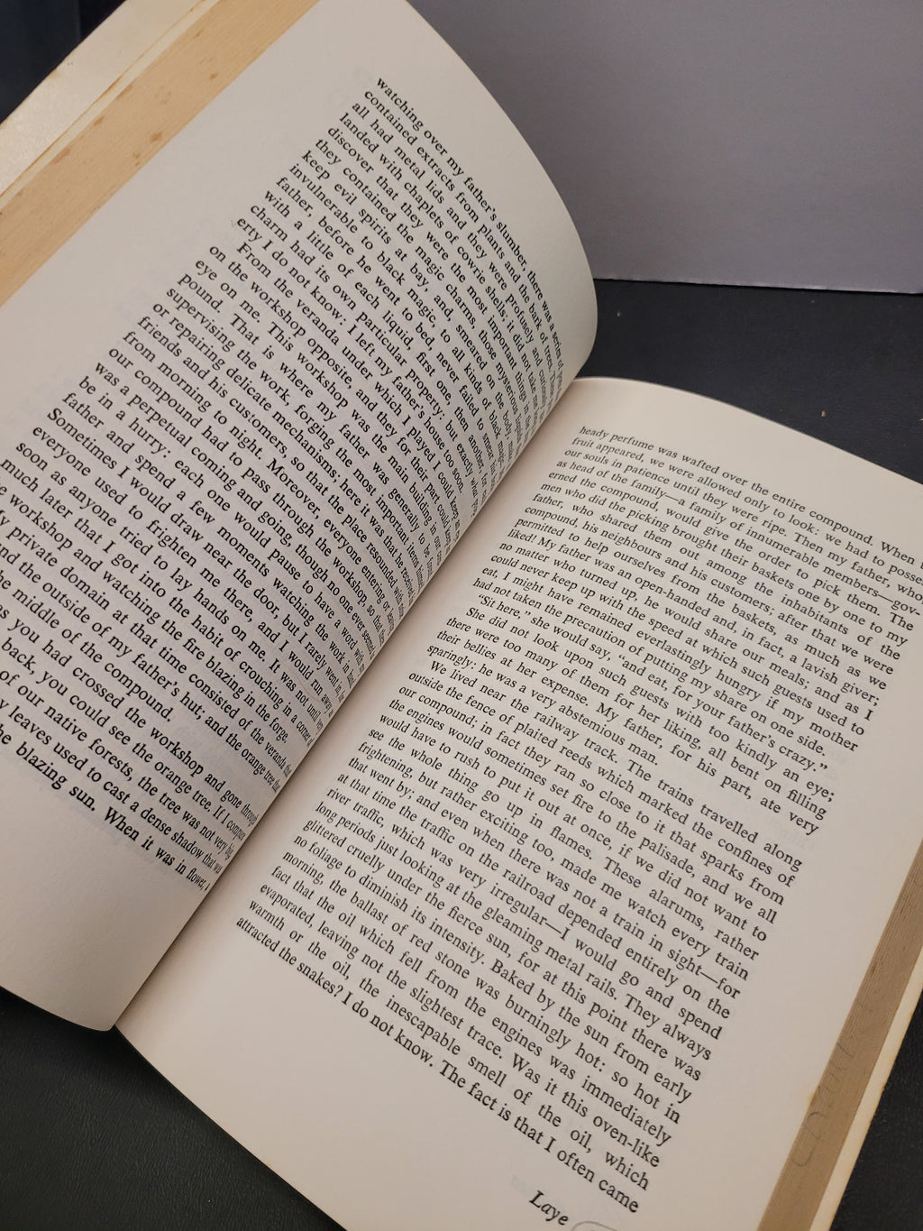 An open book "Black African Voices" with printed text on cream-colored pages, photographed at an angle against a dark background.